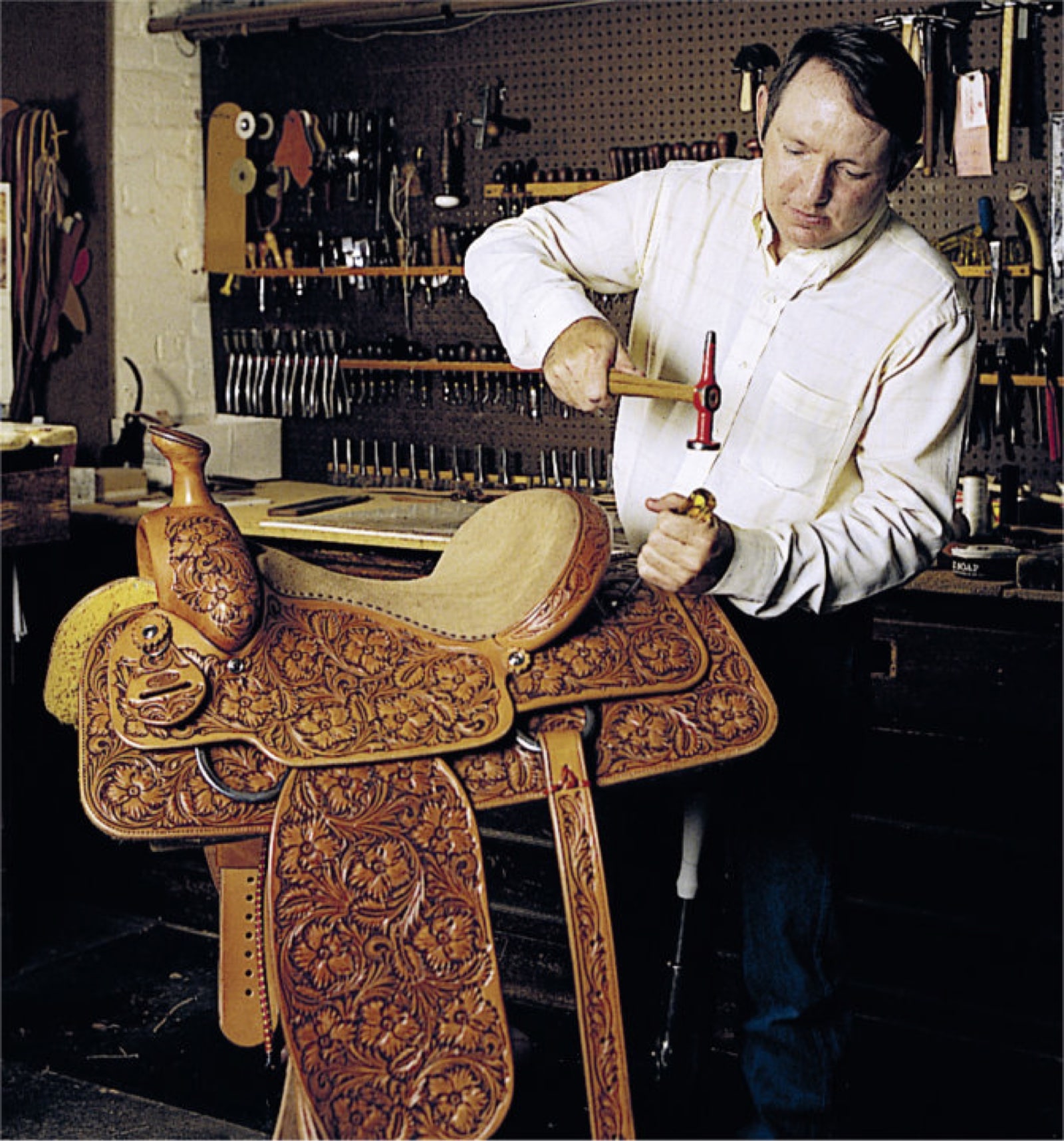 Photo of John King working with saddle